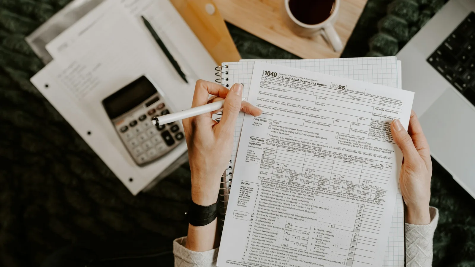 Accountant reviewing documents with a calculator and laptop